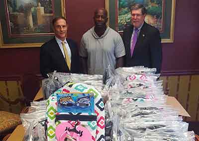E. Drew Britcher, Esq. and Armand Leone, Esq. with 100 donated backpacks for the YCS Summer Camp.